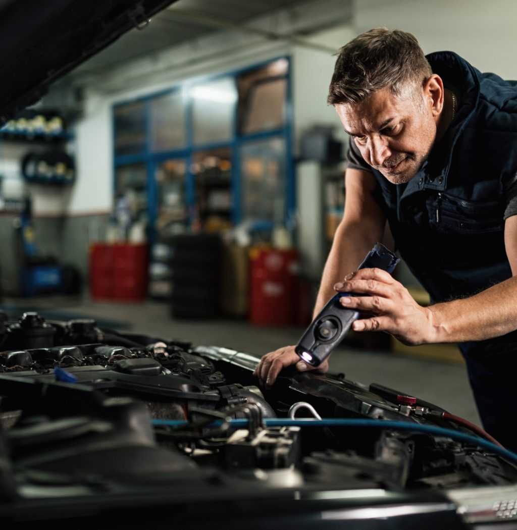mid-adult-mechanic-examining-car-engine-while-using-lamp-auto-repair-shop-scaled-1-1-1-1-1-1.jpg